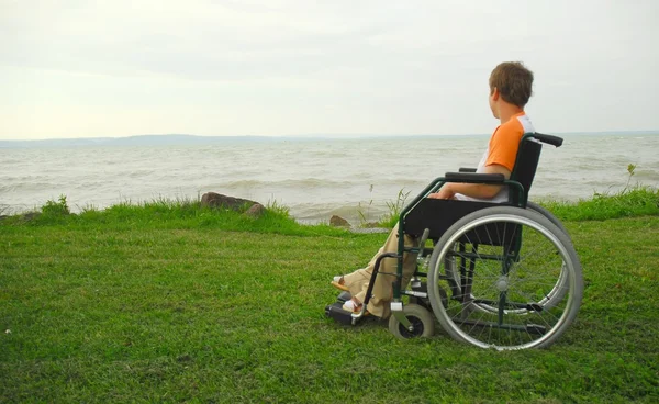Człowiek na wózku inwalidzkim, ciesząc się na plaży — Zdjęcie stockowe