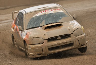 Rally car passing on a mud track clipart