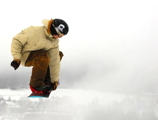 Snowboarder at jump inhigh mountains at sunny day. — Stock Photo, Image
