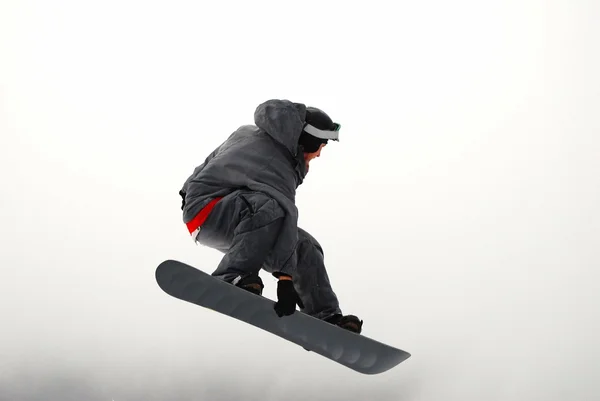 Lumilautailija hyppäämässä korkeilla vuorilla aurinkoisena päivänä. — kuvapankkivalokuva