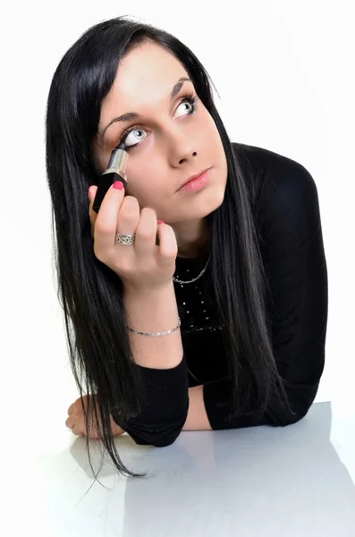 Uma mulher adulta bonita a fazer maquilhagem à volta dos olhos. Modelo posando sobre branco — Fotografia de Stock