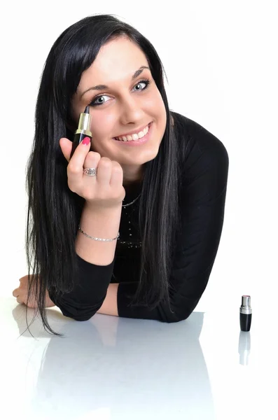 Mooie jonge vrouw met lippenstift in haar hand met focus op gezicht — Stockfoto