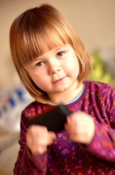 Маленькая девочка говорит по мобильному телефону, белый фон — стоковое фото