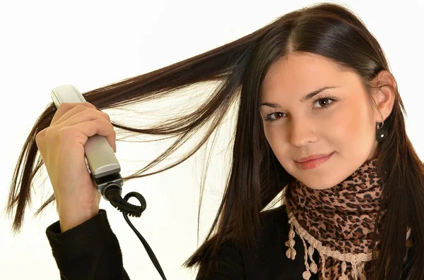 Portrait of young beautiful girl doing hairstyle with hair iron — Stock Photo, Image