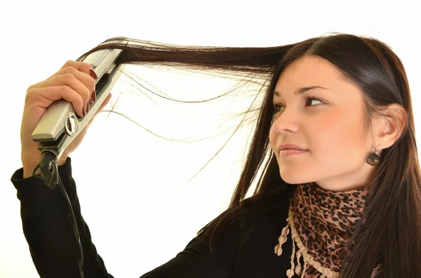 Портрет молодої красивої дівчини, що робить зачіску з залізом — стокове фото
