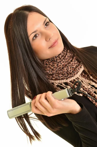 Retrato de una joven hermosa chica haciendo peinado con plancha de pelo — Foto de Stock