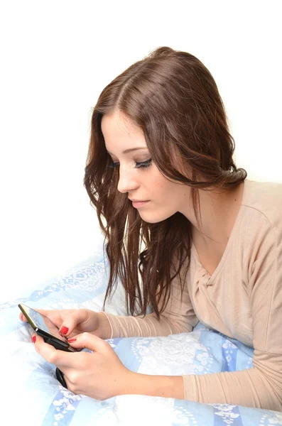 Attraktive junge Frau telefoniert im Bett. — Stockfoto