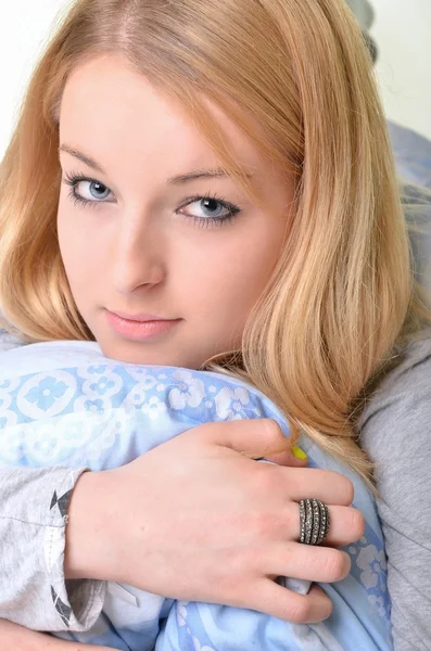 Ung vacker flicka i en säng — Stockfoto