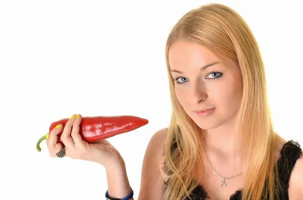 Ganska leende kvinna håller en röd paprika. isolerade över vit bakgrunds — Stockfoto