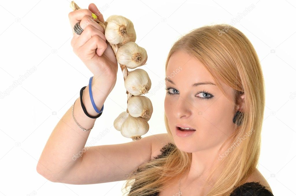 Young beautiful woman eating garlic. Healthy eating concept. Natural antibi