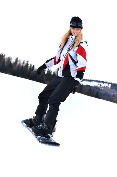 Mujer con snowboard de pie en la cima de la montaña nevada —  Fotos de Stock