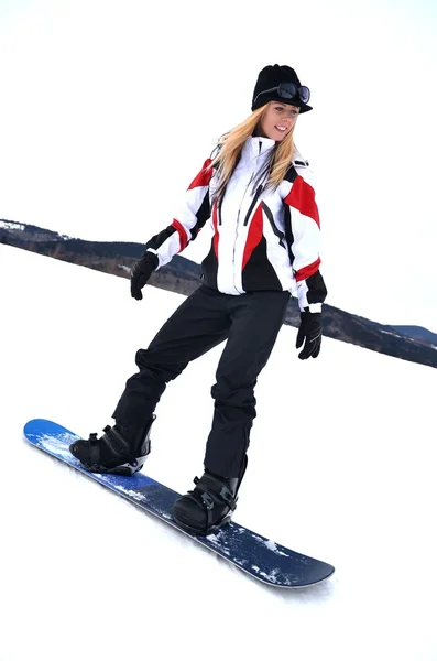 Femme avec snowboard debout au sommet d'une montagne enneigée — Photo