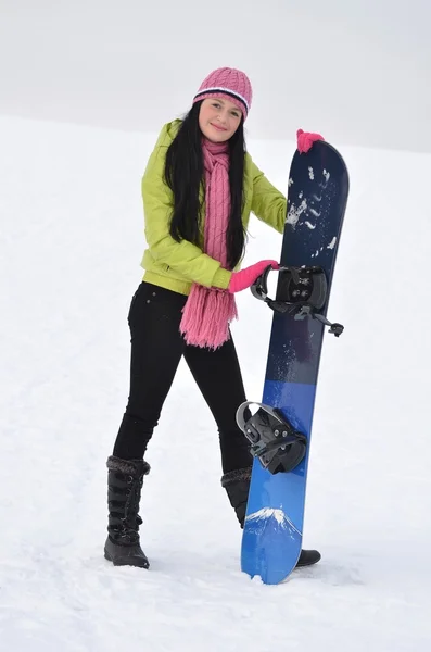 Mulher com snowboard em pé no topo da montanha nevada — Fotografia de Stock