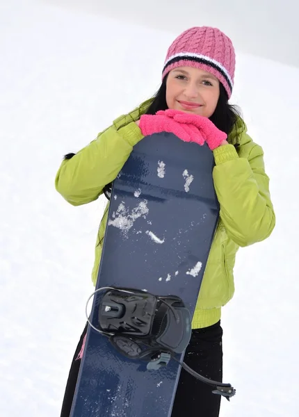 Žena s snowboardu stojící na vrcholu zasněžené hory — Stock fotografie