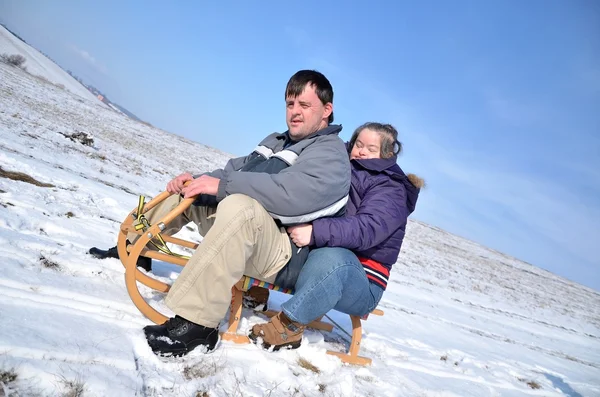 Down syndrome couple sledding — Stock Photo, Image