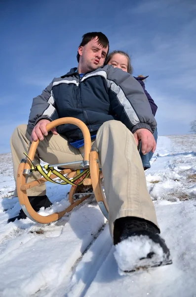 Down syndrome couple sledding — Stock Photo, Image
