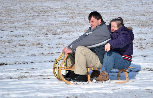 Stock image Down syndrome couple sledding