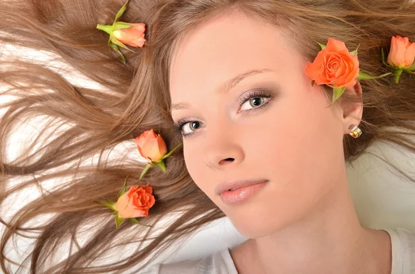 Schöne junge Frau mit Rosen — Stockfoto
