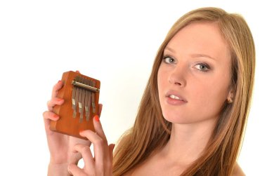 Relaxed woman playing on a version of the African instrument Kalimba clipart