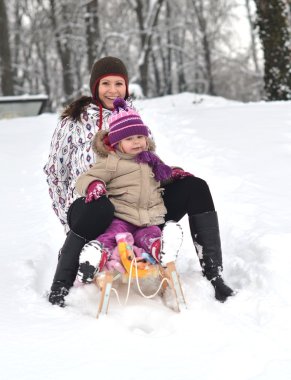 Anne ve kızı güzel kış sahne sledging,