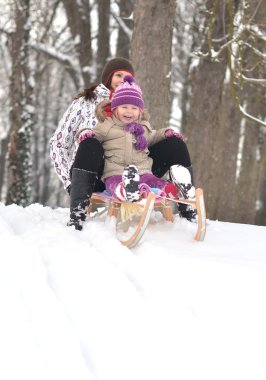 Anne ve kızı güzel kış sahne sledging,