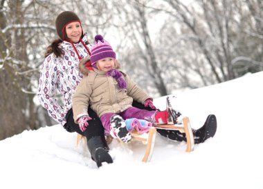 Anne ve kızı güzel kış sahne sledging,