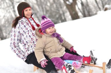 Mother and daughter sledging, nice winter scene clipart