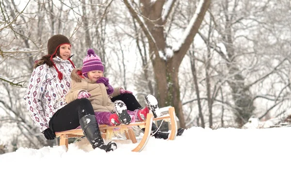 母と娘スレッジング、素敵な冬のシーン — ストック写真
