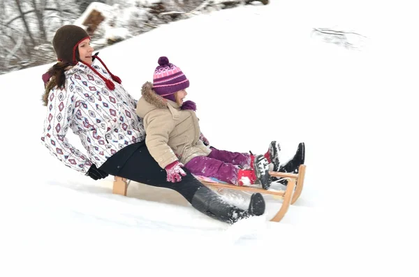 Anne ve kızı güzel kış sahne sledging, — Stok fotoğraf