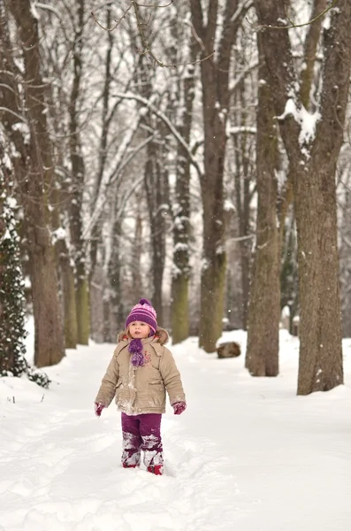 Glückliches kleines Kind spielt im Schnee — Stockfoto