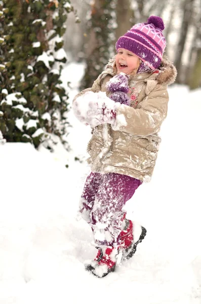 Glückliches kleines Kind spielt im Schnee — Stockfoto