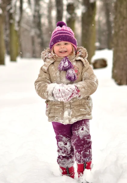 幸せな小さな子供は雪で遊ぶ — ストック写真