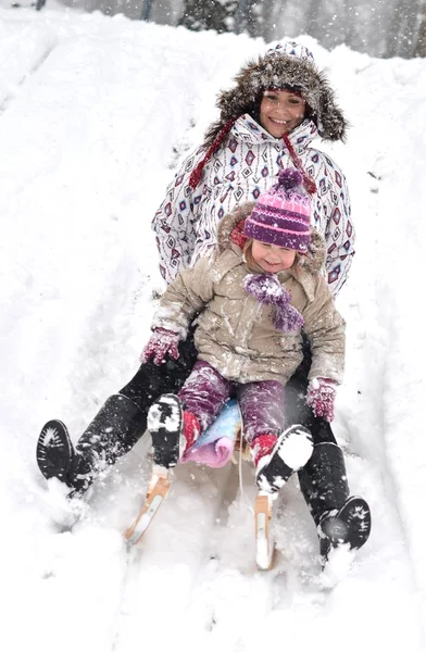 Madre e hija trineo, escena de invierno agradable —  Fotos de Stock