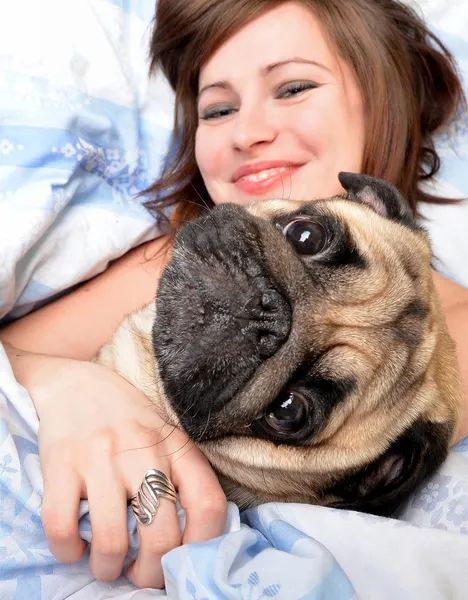 Mujer con perro en la cama — Foto de Stock