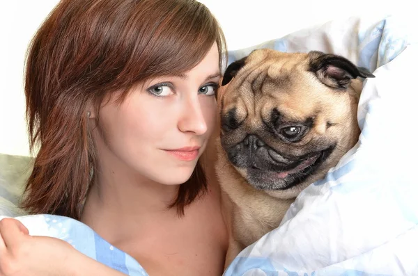 Mujer y su perro durmiendo cómodamente en la cama — Foto de Stock