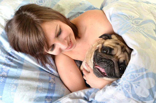 Женщина и ее собака комфортно спят в кровати — стоковое фото