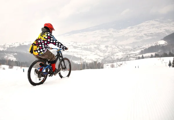 在冬天骑雪径山骑自行车的人 — 图库照片