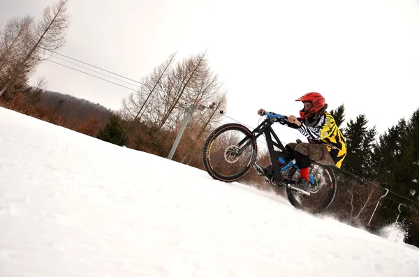 在冬天骑雪径山骑自行车的人 — 图库照片