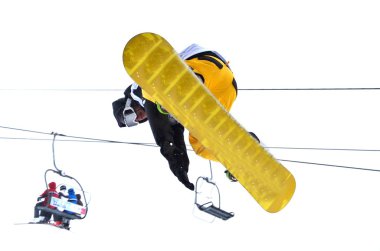 Snowboarder at jump inhigh mountains at sunny day. clipart