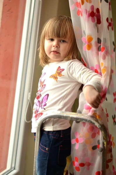 Barn girl titta på fönstret — Stockfoto