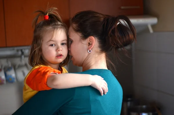 Матері, тримаючи свою дитину на руках на кухні — стокове фото