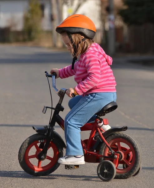 Маленькая девочка едет на велосипеде — стоковое фото