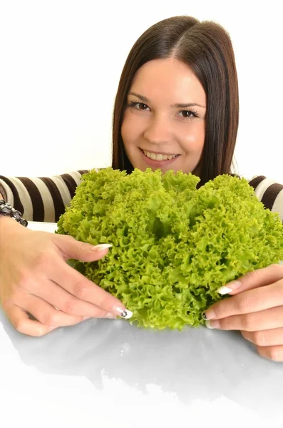 Gelukkig jonge vrouw bedrijf groene sla en glimlachend, op witte achtergrond — Stockfoto