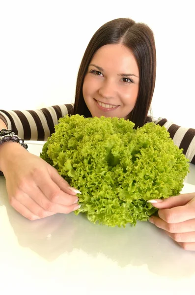 Šťastná mladá žena držící zeleného salátu a usmívá se, bílé pozadí — Stock fotografie