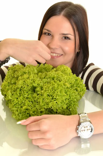 Wanita muda bahagia memegang selada hijau dan tersenyum, di atas latar belakang putih — Stok Foto