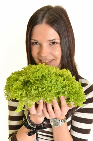 Счастливая молодая женщина держит зеленый салат и улыбается, на белом фоне — стоковое фото