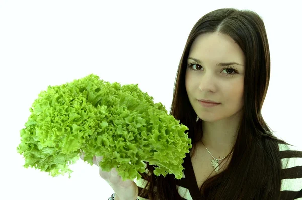 Счастливая молодая женщина держит зеленый салат и улыбается, на белом фоне — стоковое фото