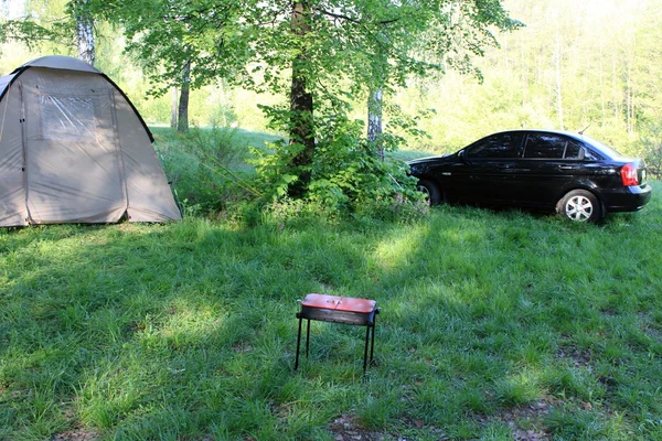 Палатка, машина и барбекю летом — стоковое фото