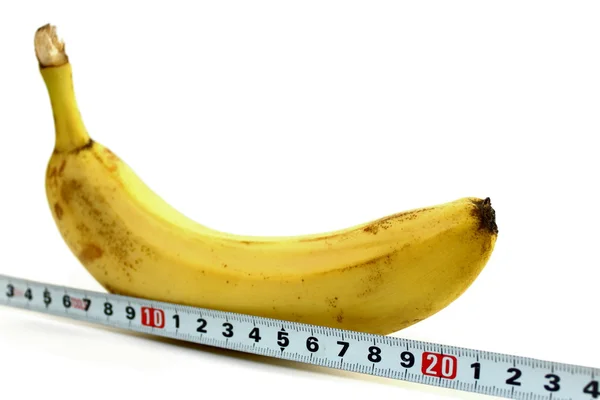 Grande banane et ruban à mesurer sur blanc — Photo