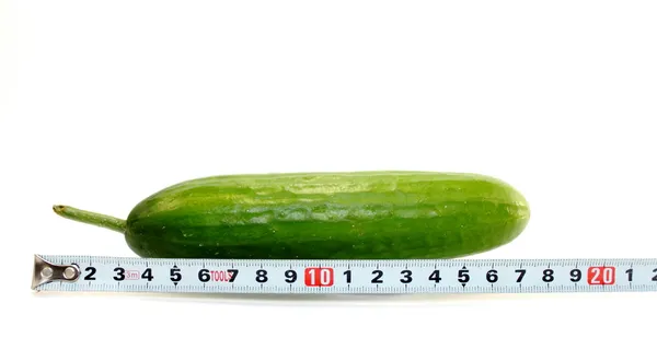 Grote komkommer en een meetlint op wit — Stockfoto
